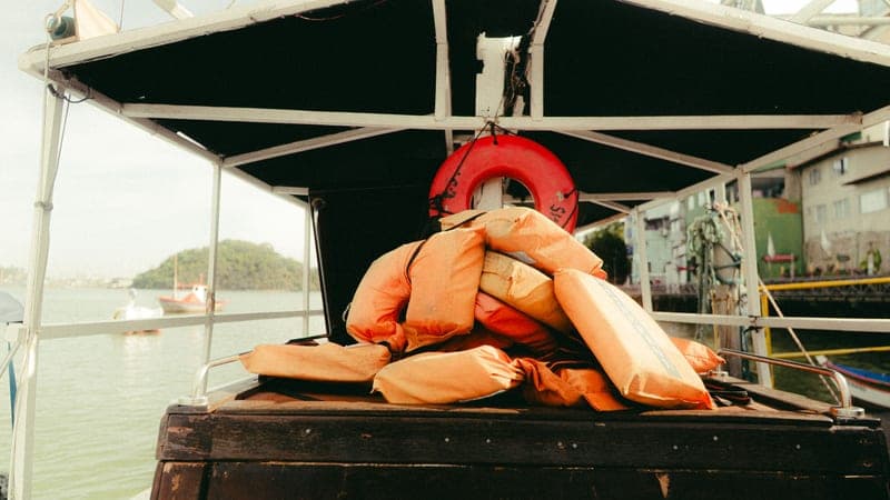 An orange life jacket lying on the deck of a boat